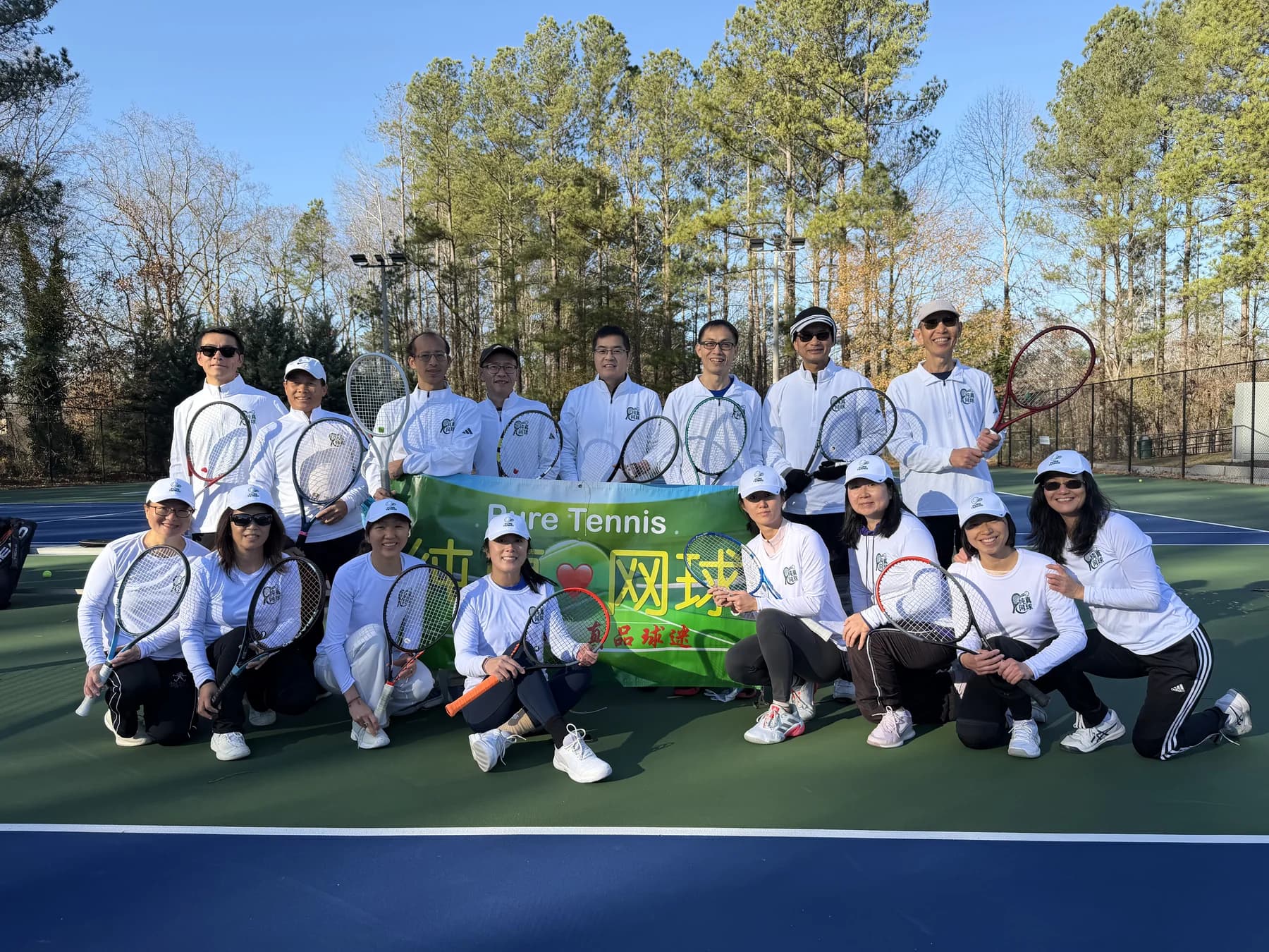 Pure Tennis community members gathered around their tennis banner