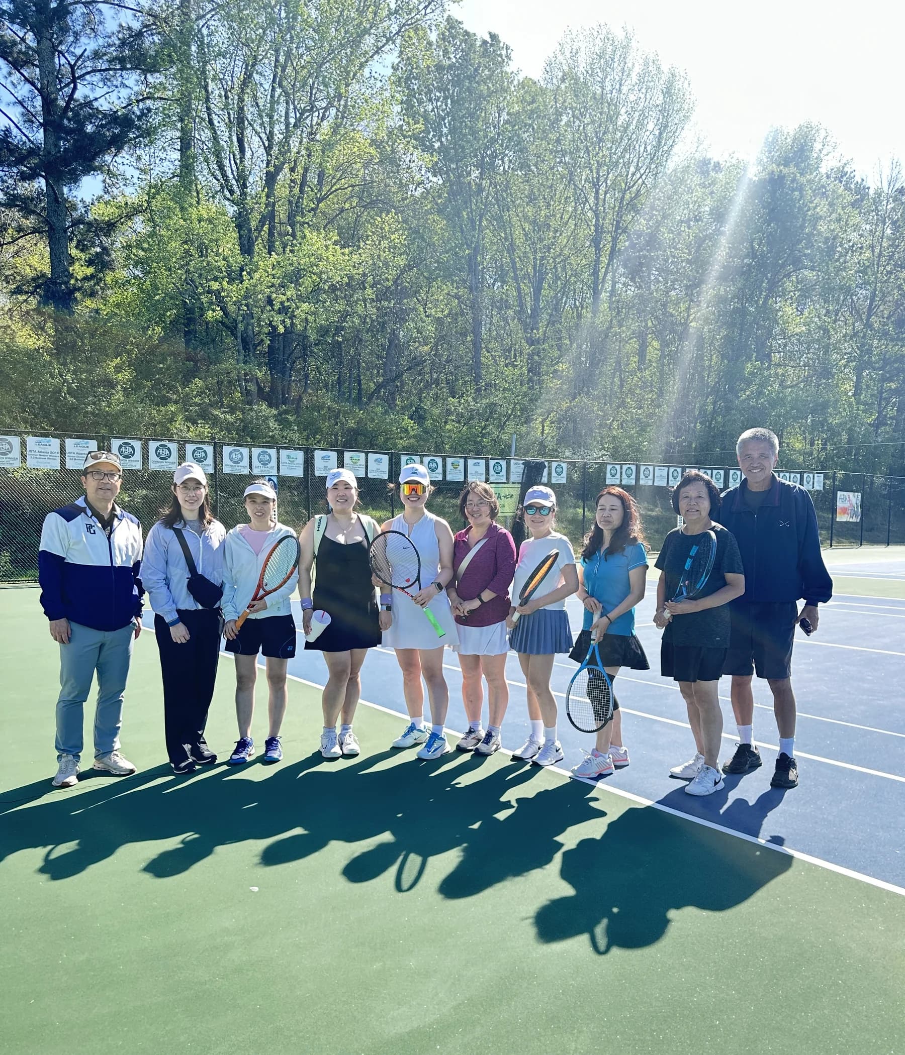 AARSA players gathered with racquets on a sunny tennis court